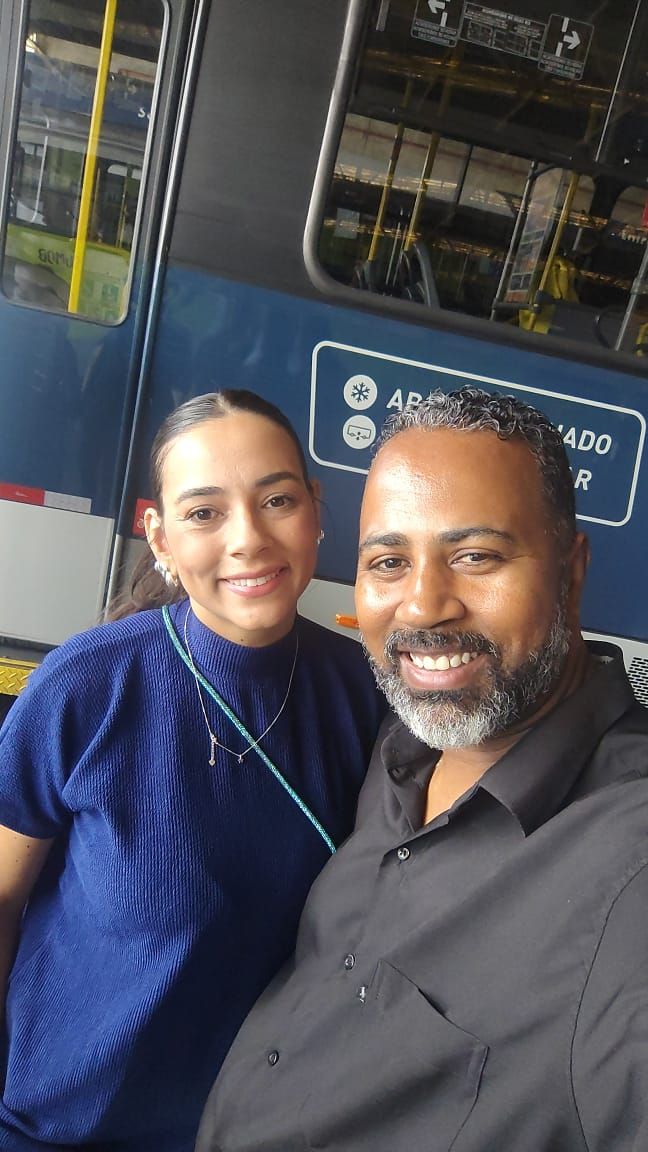 Integrantes da M.Marques em uma garagem de ônibus, ao lado de um veículo da frota